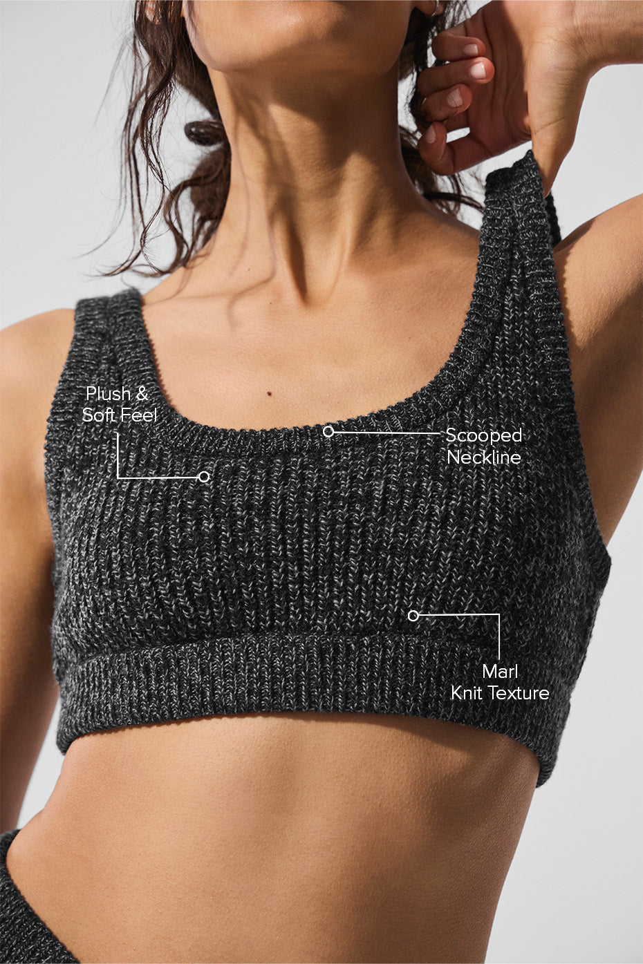 Model wearing the sweater bra layered under a green knitwear sweater