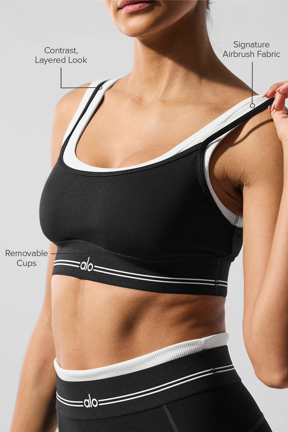 Model wearing Alo Yoga sports bra during a yoga class, highlighting comfort and support.