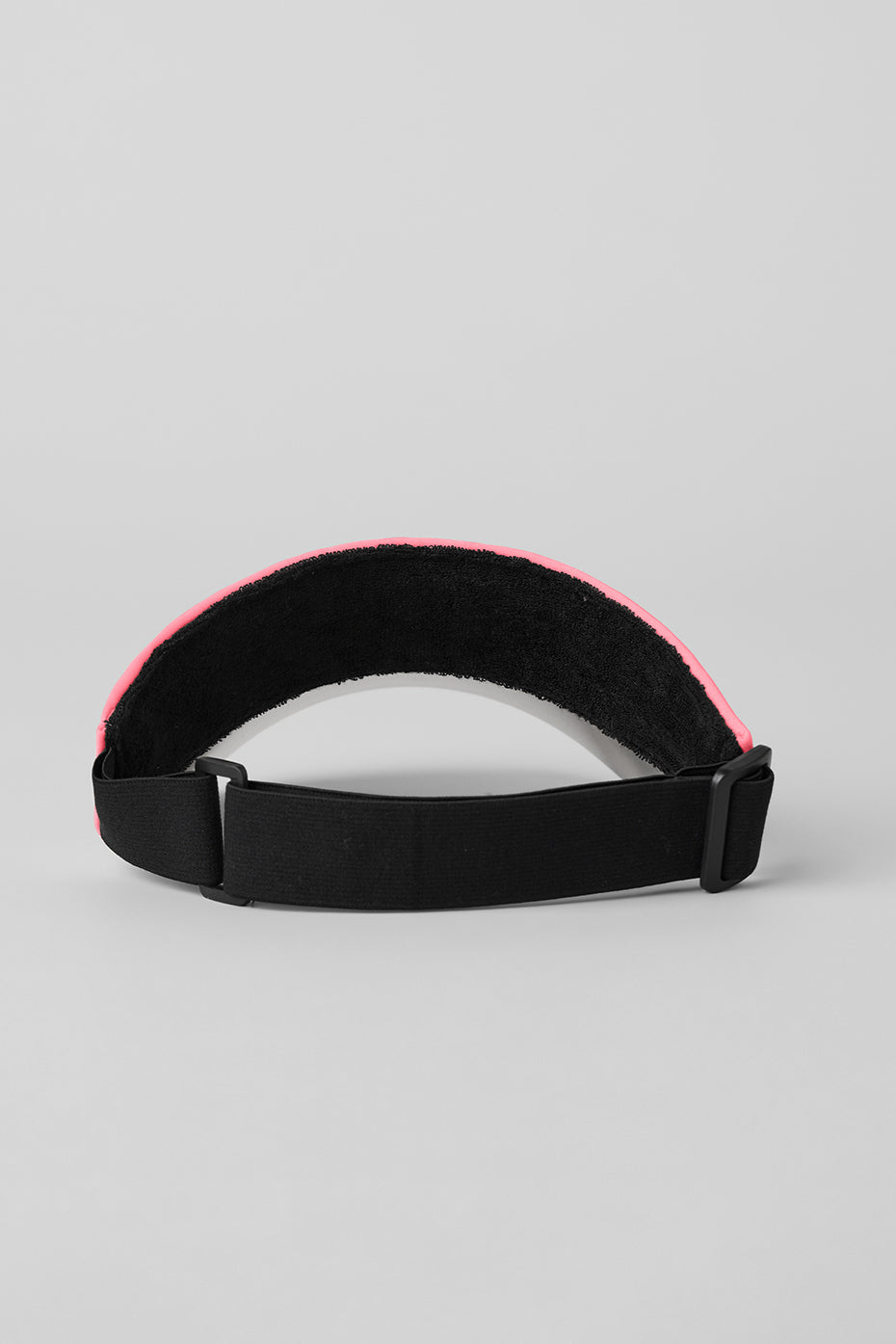 Front view of the neon bubblegum tennis visor on a sunny day.