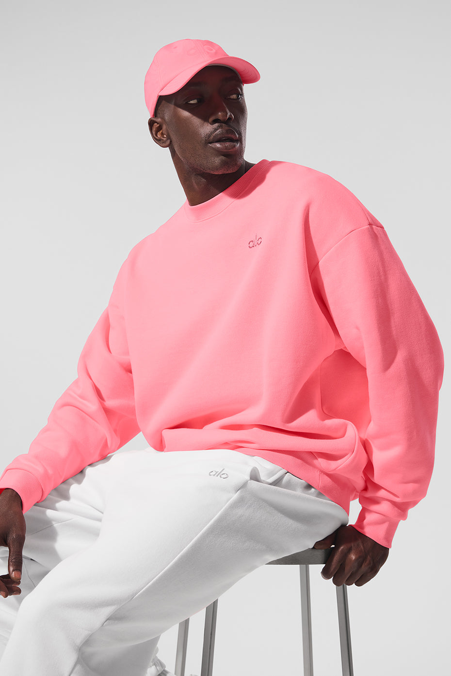 Front view of the Accolade crew neck pullover in neon bubblegum showing the chrome logo