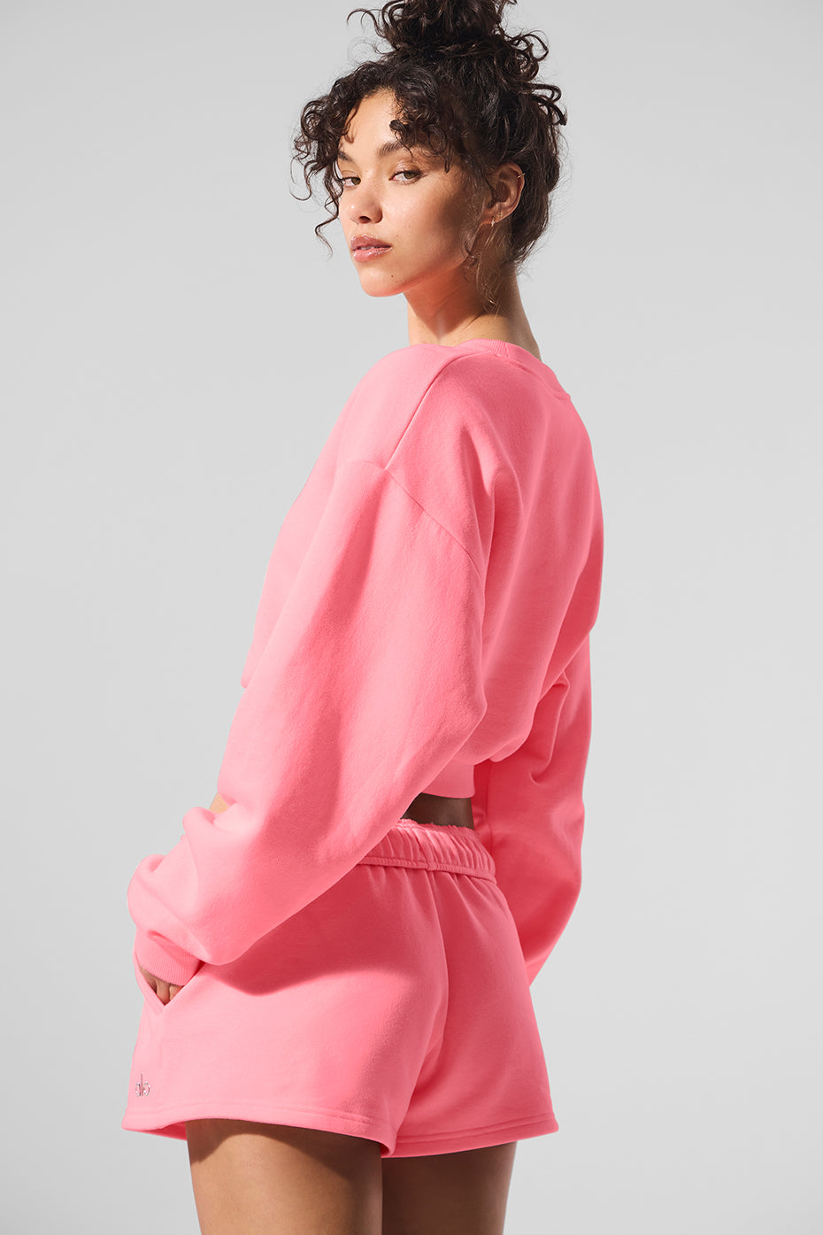 Model wearing the neon crewneck sweatshirt during a city outing.