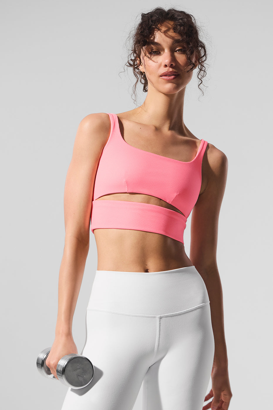 Back cutout detail of yoga bra shown with high-waist leggings in urban setting
