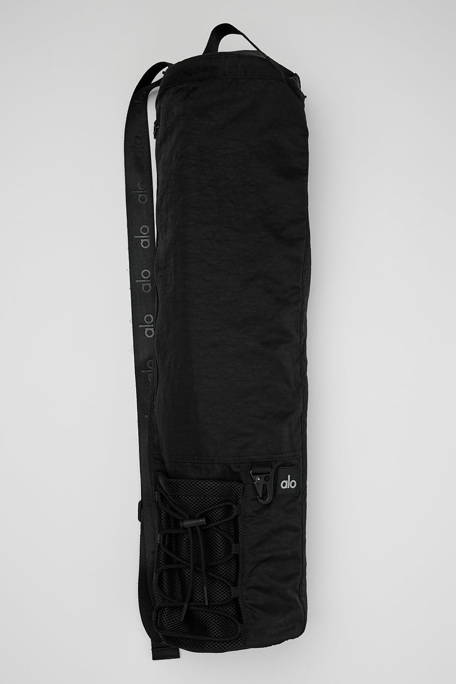 Front view of the Alo Yoga Mat Yoga Bag in black, showcasing its adjustable strap.