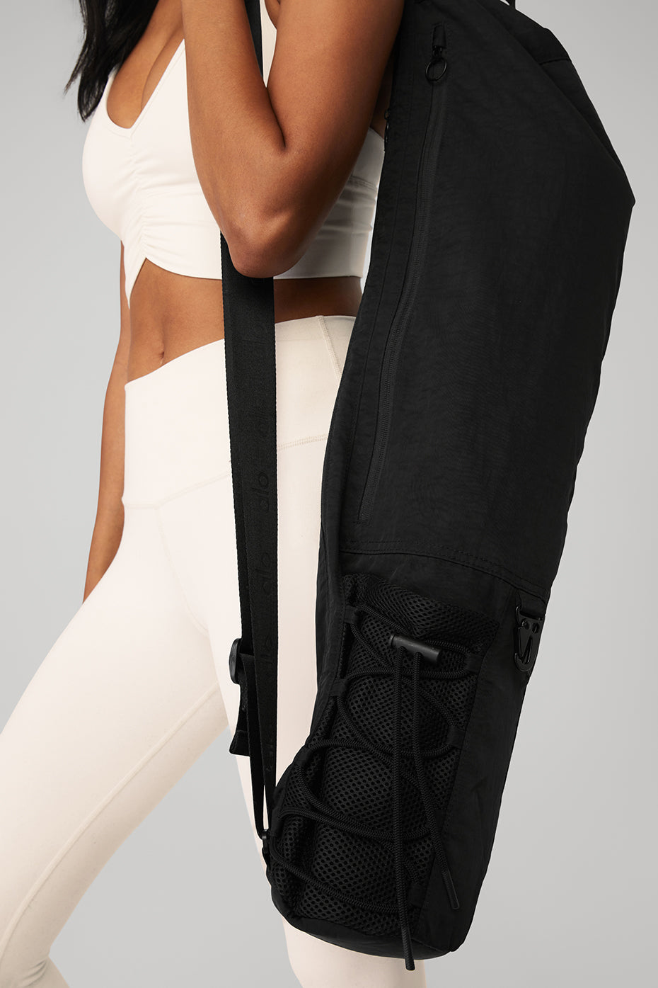 Front view of the Alo Yoga Mat Yoga Bag in black, showcasing its adjustable strap.
