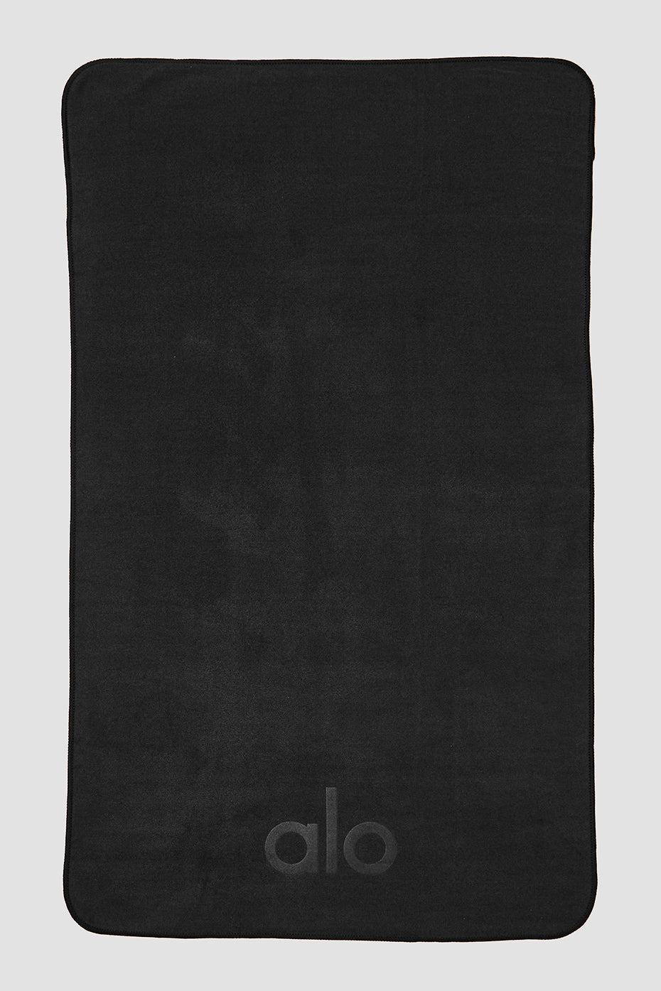 Close-up of the black microfiber yoga towel showing its texture.