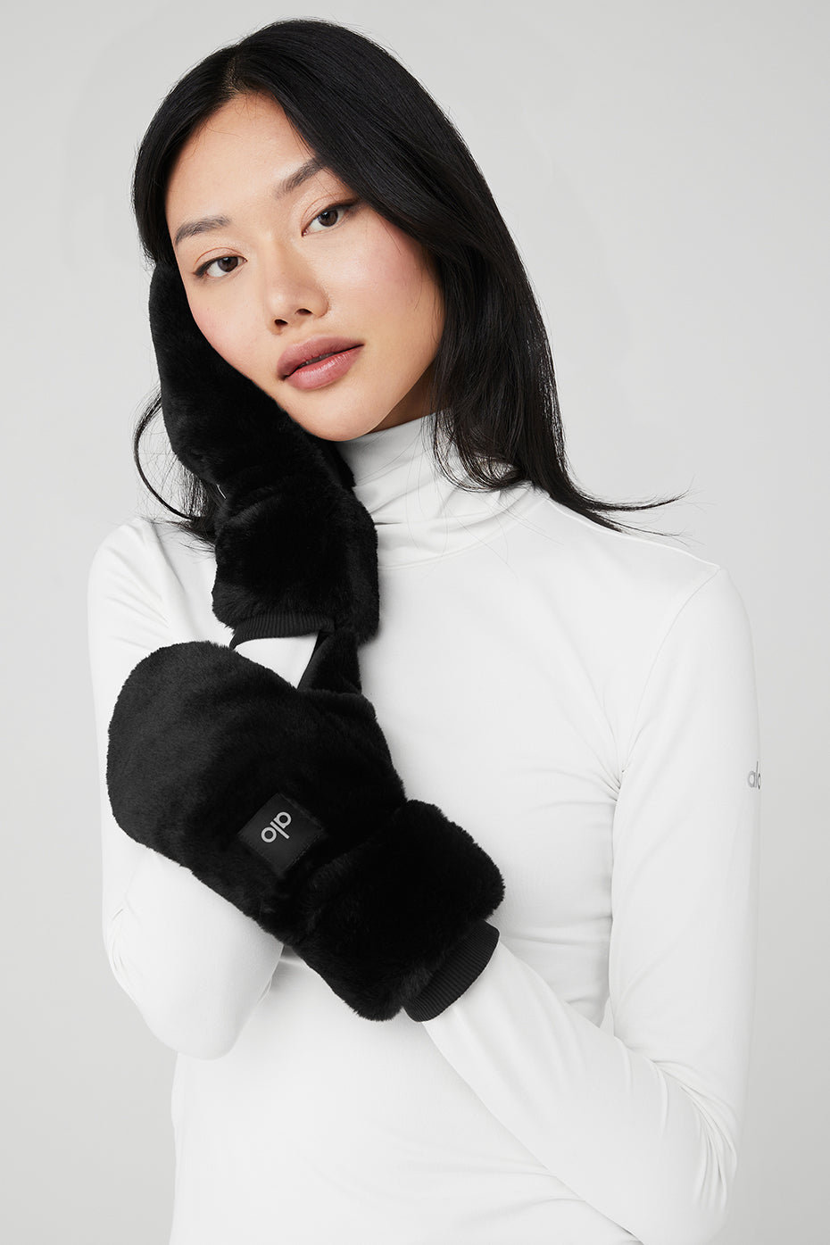 Close-up of fleece-lined faux fur mittens in black
