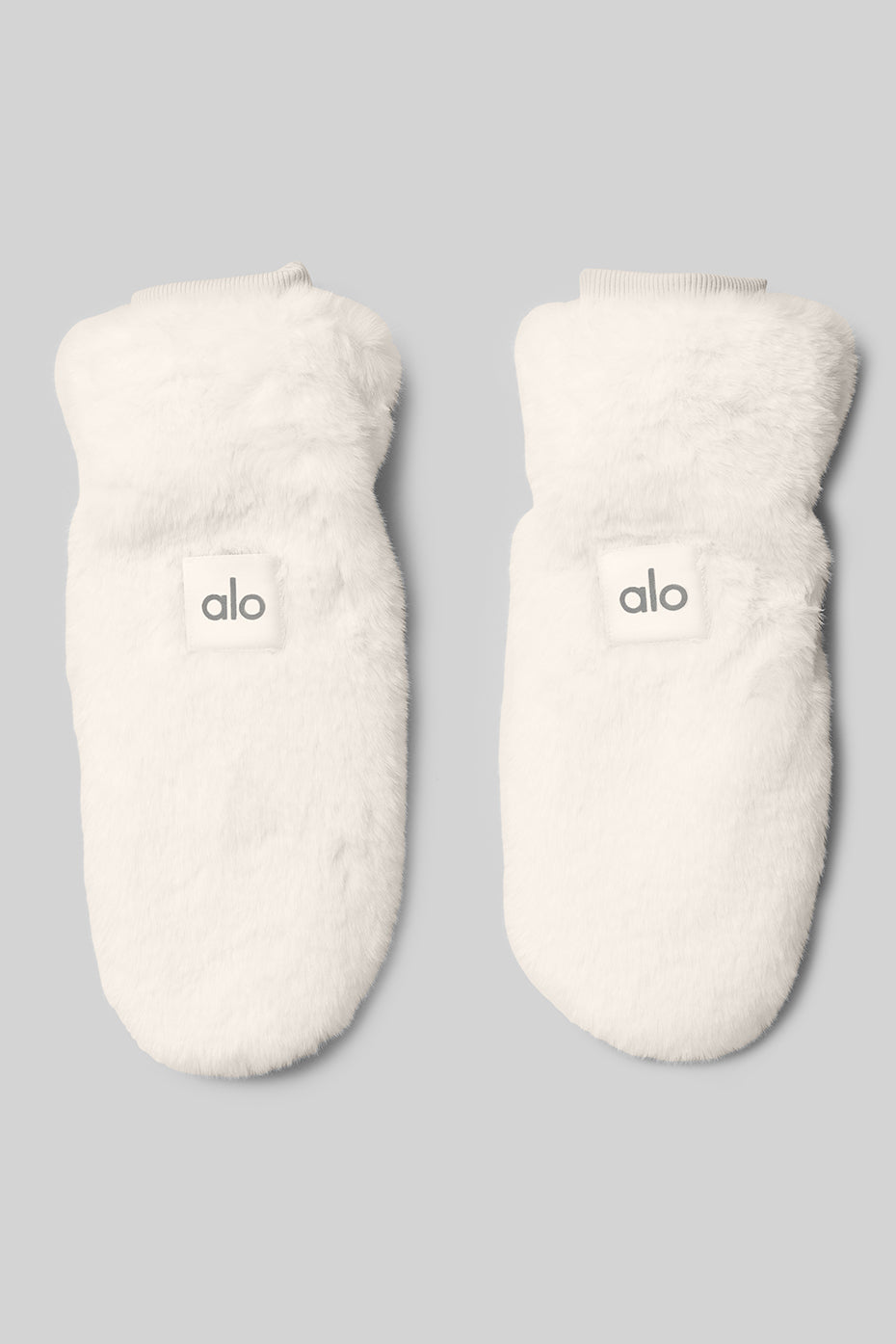 Close-up of ivory faux fur mittens showcasing plush interior.