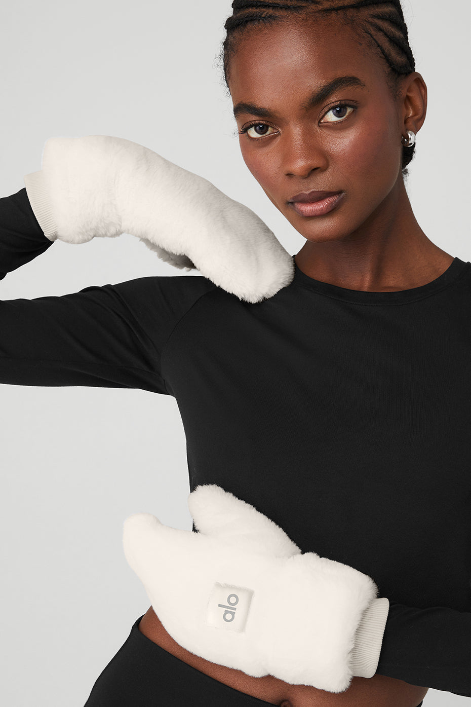 Ivory faux fur mittens displayed on a snowy background.