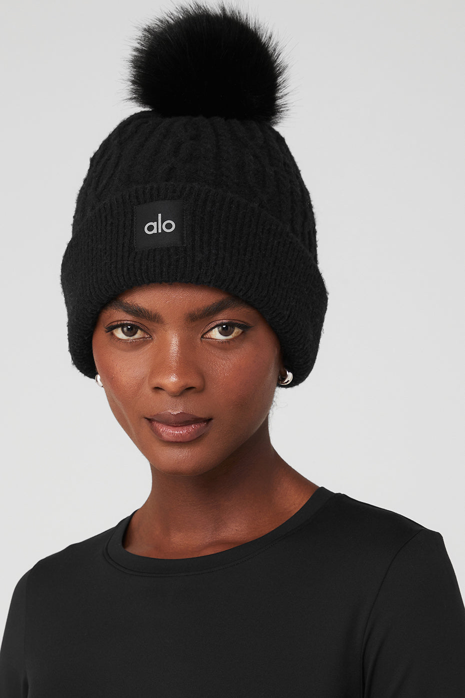 Model wearing a stylish black beanie during a snowy day.