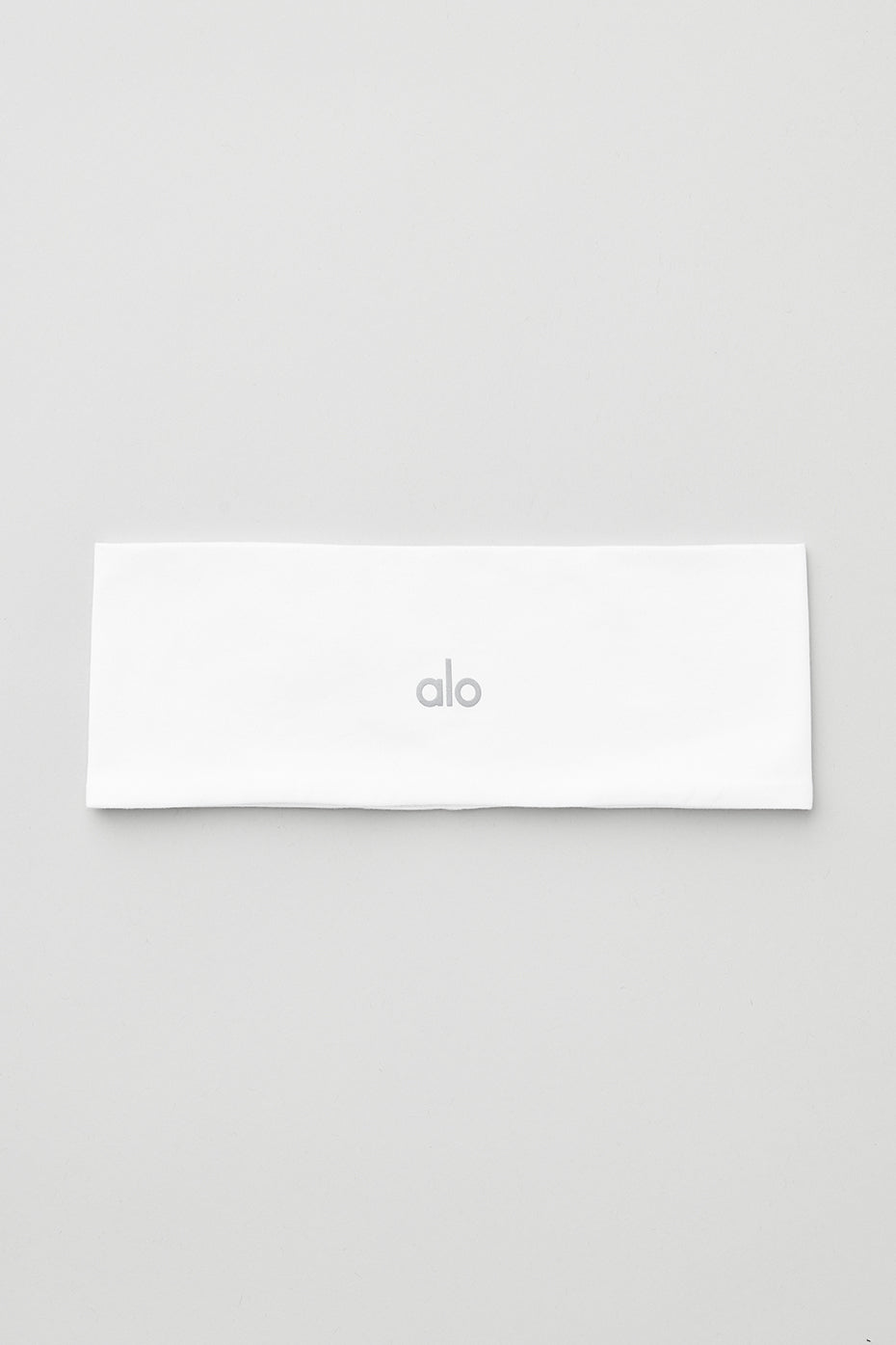 Close-up of the Conquer Performance Headband in white, showcasing its snug fit.