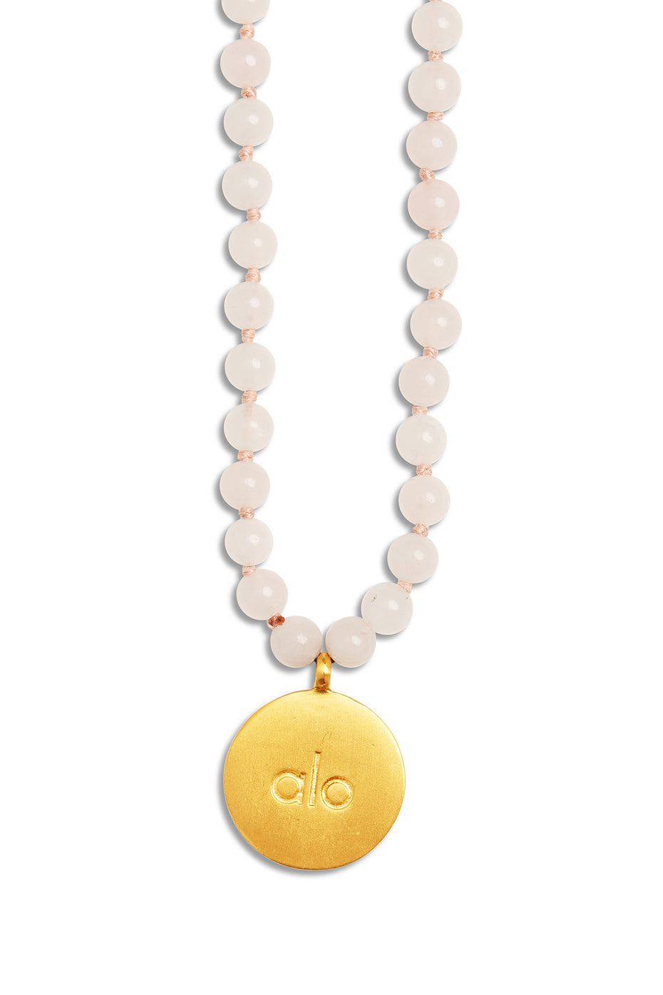 Hand holding mala necklace for meditation, blurred nature background