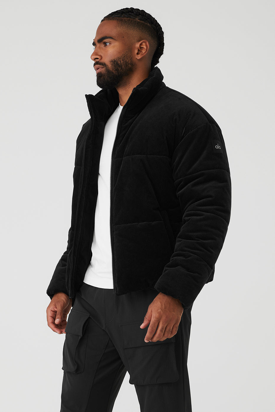 Model wearing a long black winter jacket in an urban setting.