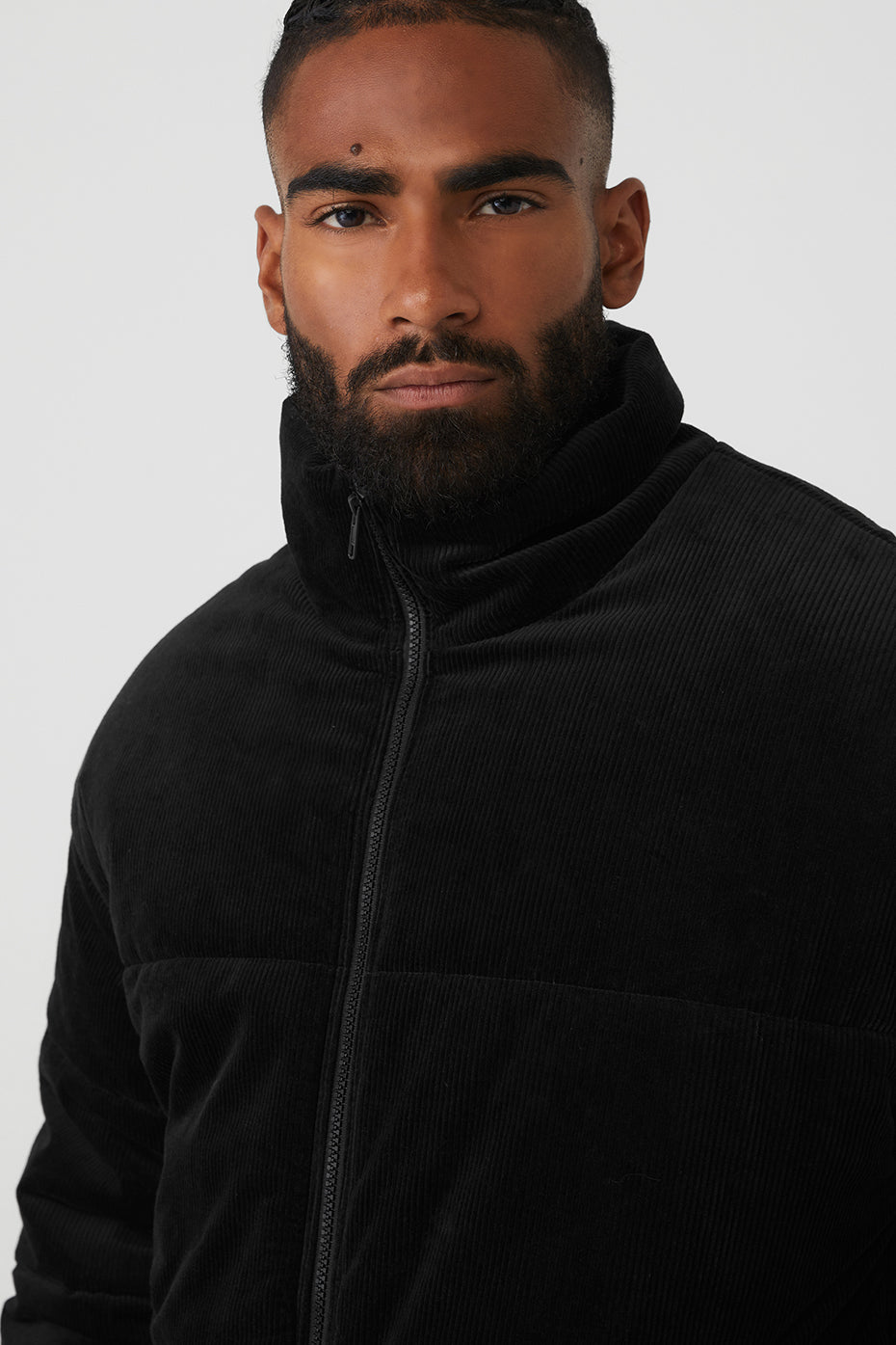 Front view of cozy black winter jacket with zippered side pockets.