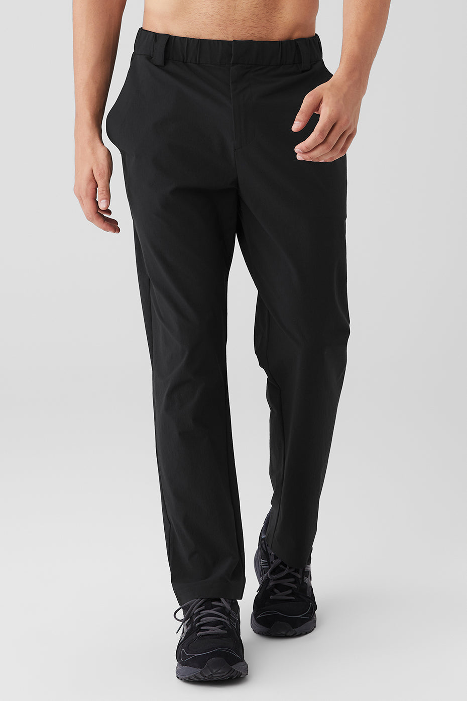 Close-up of tailored black dress pants with zippered pockets and cropped fit for street style