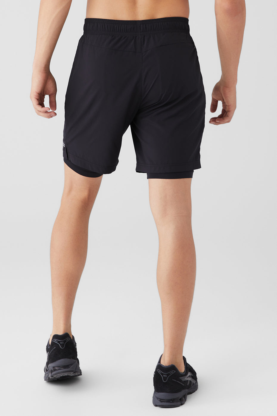 Model wearing Unity Performance 2-in-1 shorts while jogging outdoors.