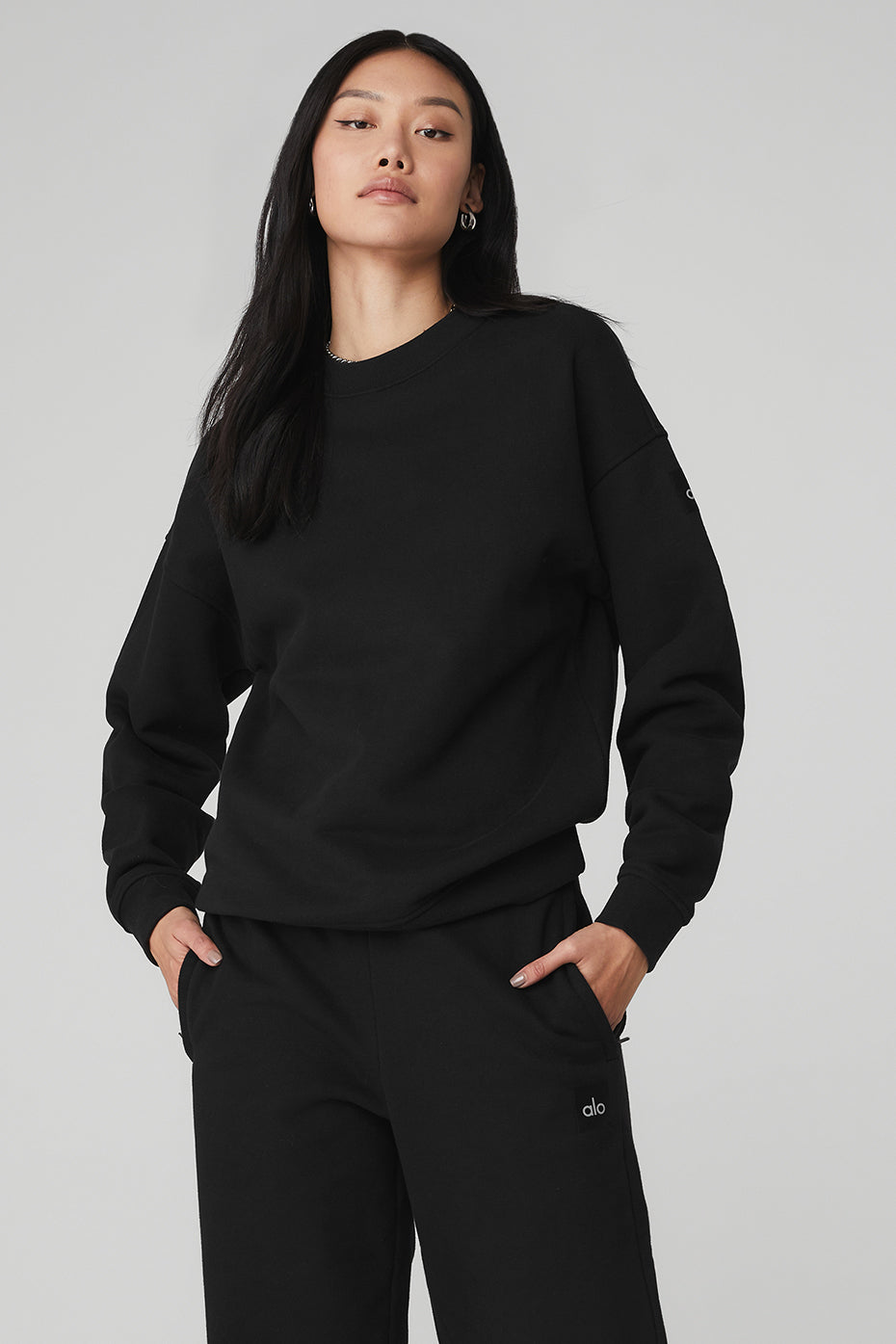 Model wearing black heavyweight French terry pullover on city street
