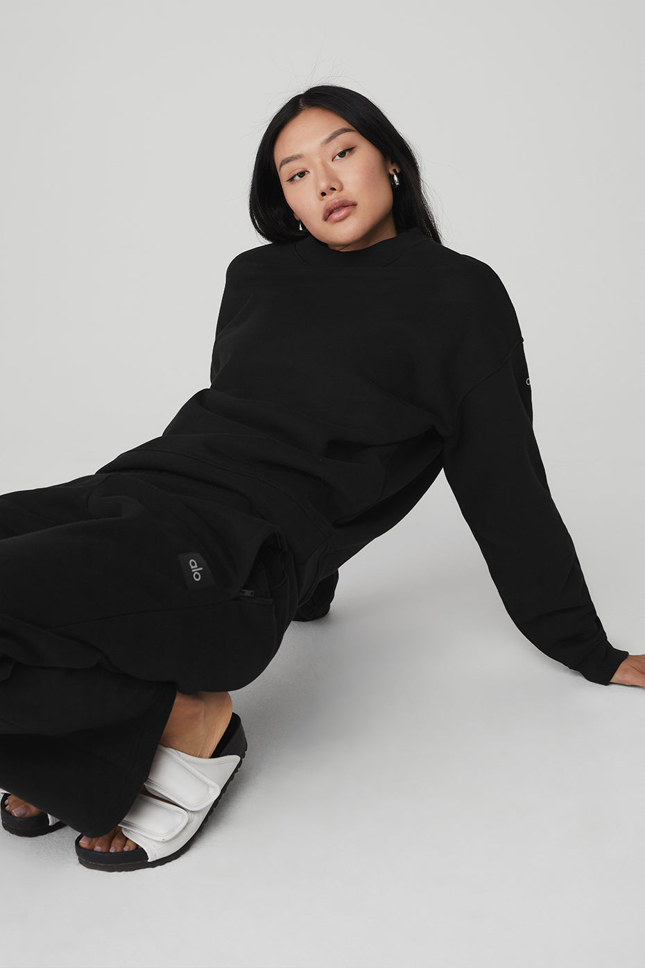 Model wearing black heavyweight French terry pullover on city street