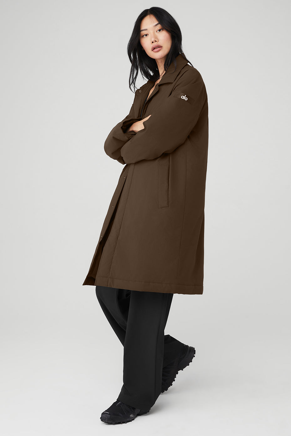 Model walking in espresso overcoat through downtown Dallas streets
