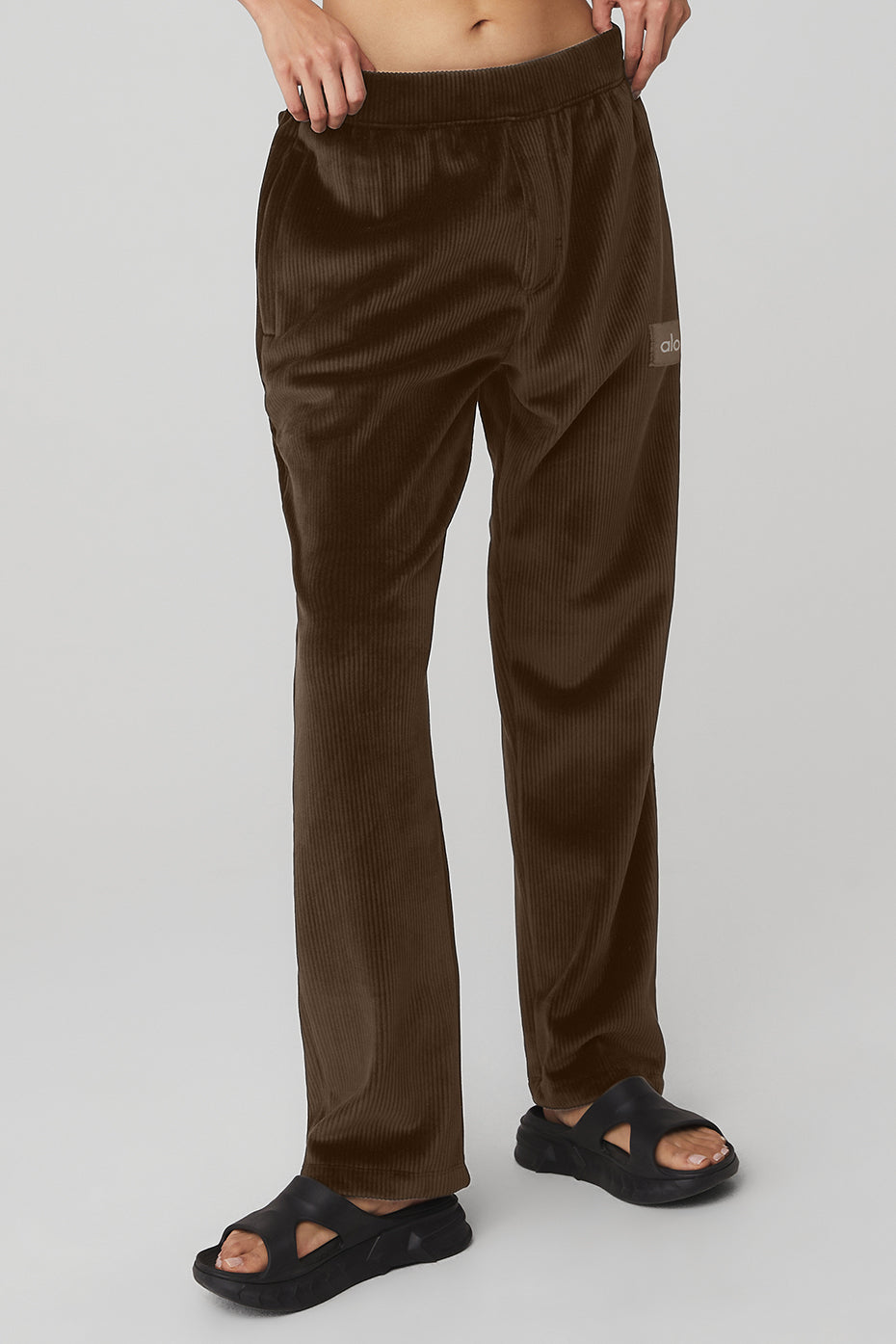 Side view of espresso velour baller pants in a relaxed pose.