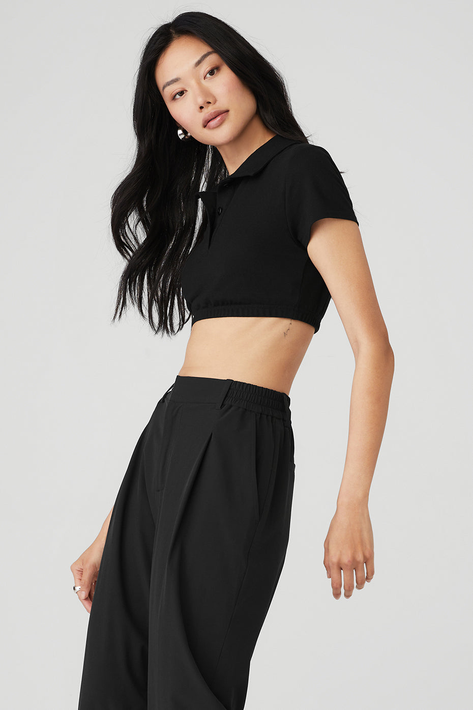 Back view of black cropped polo showing tailored silhouette