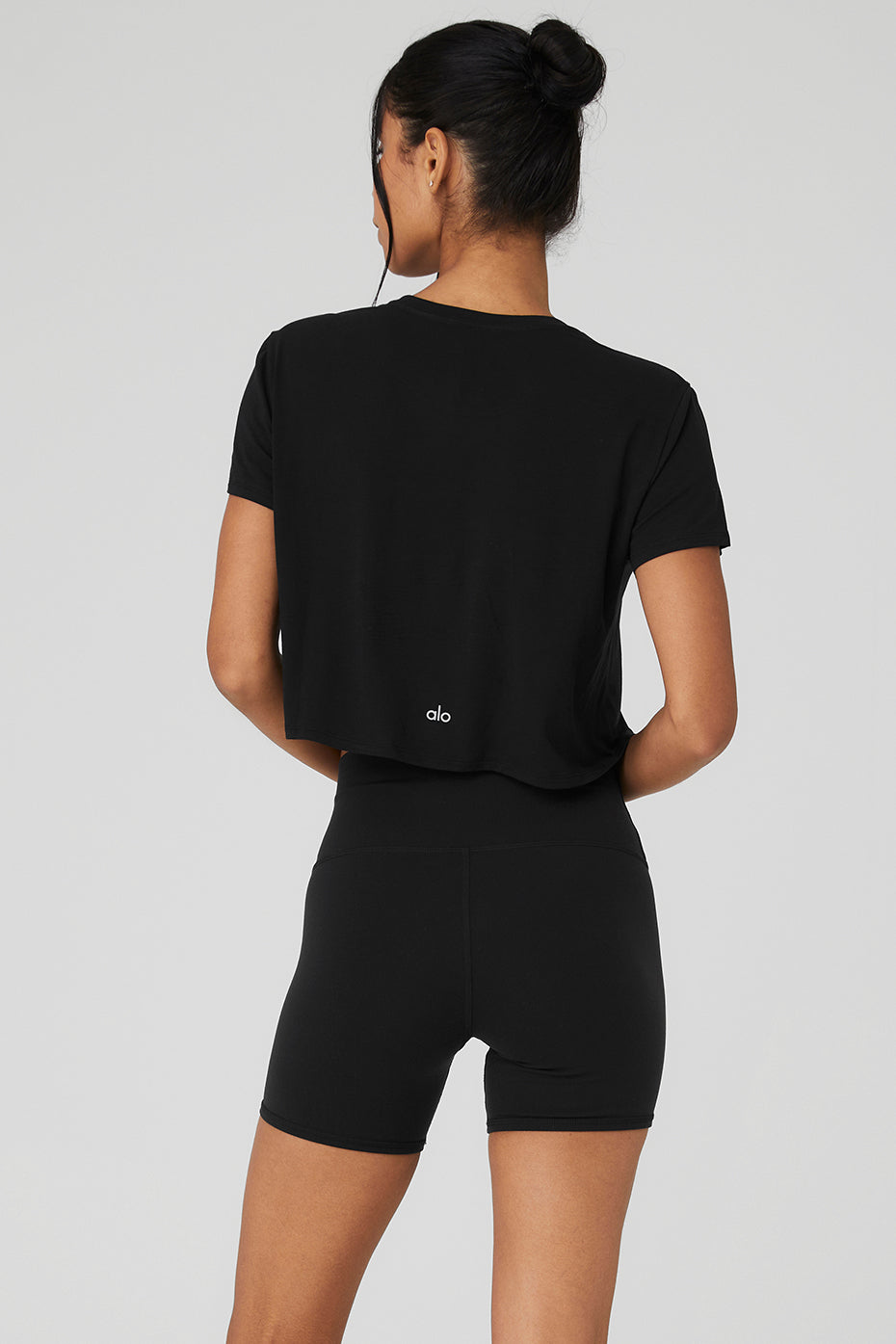 Model wearing a cropped t-shirt under a light jacket for a chic look.