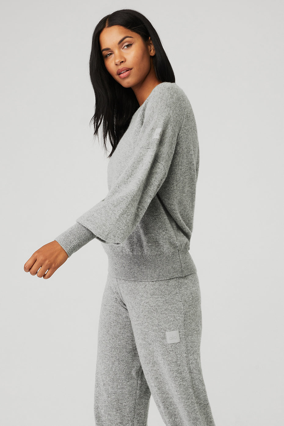 Stylish grey cashmere jumper displayed on a wooden hanger