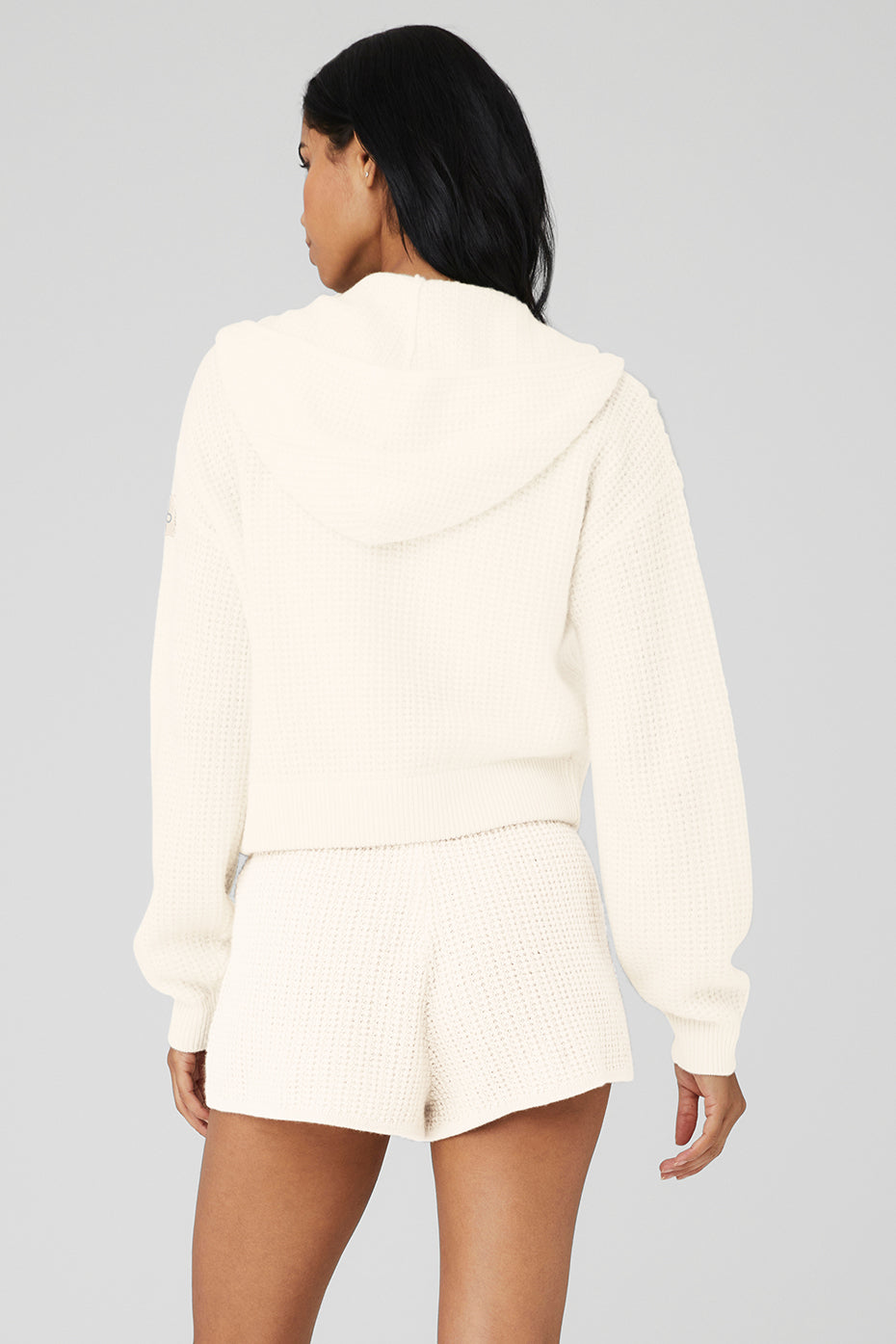 Model wearing the cashmere zip hoodie, styled with high-waist shorts for a trendy look.
