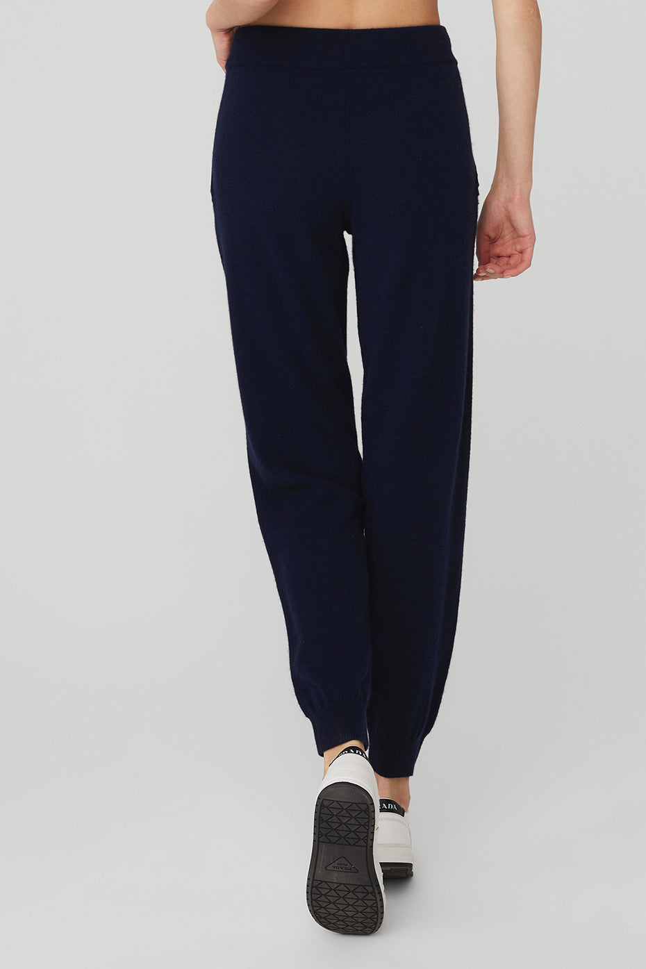 Model wearing navy cashmere wide leg pants with a relaxed white blouse