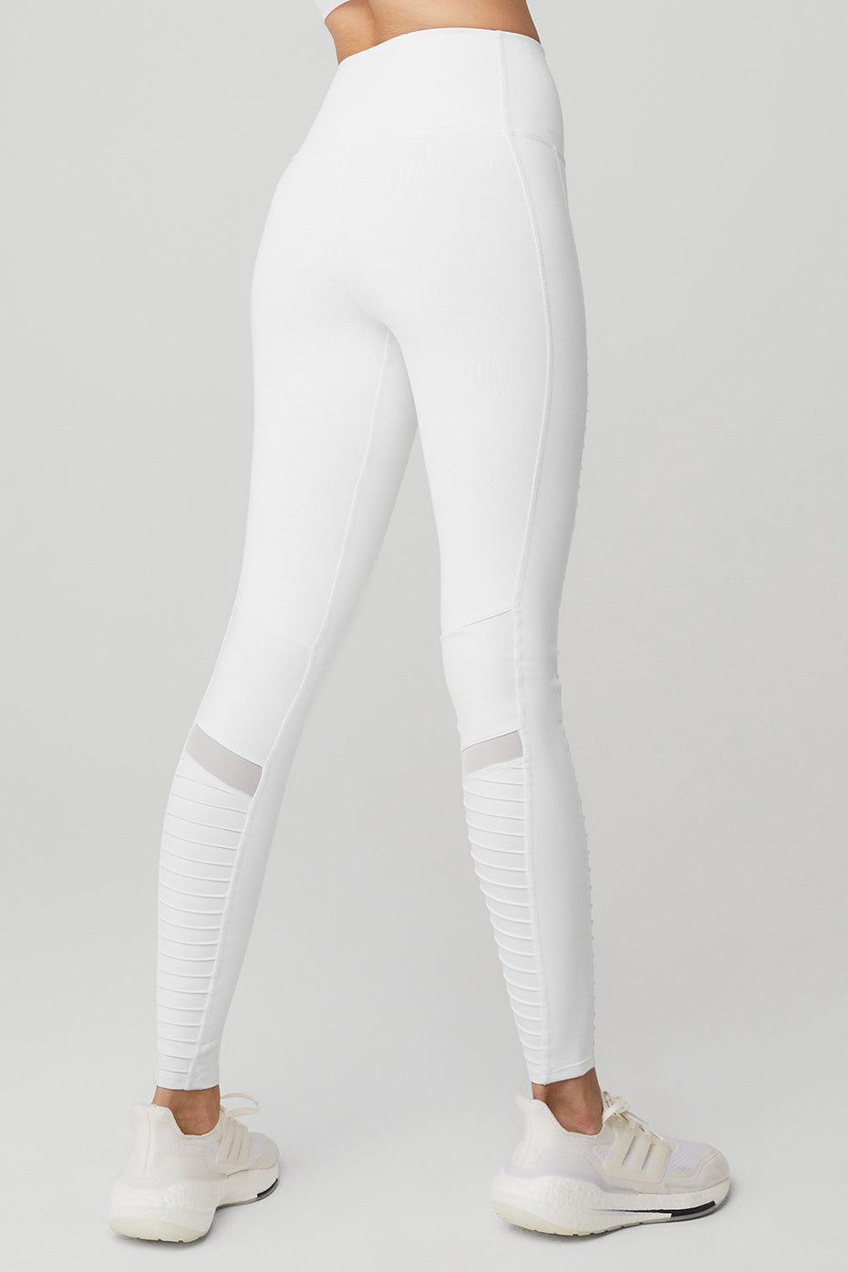Side angle showing mesh panels and contouring fit of white moto leggings