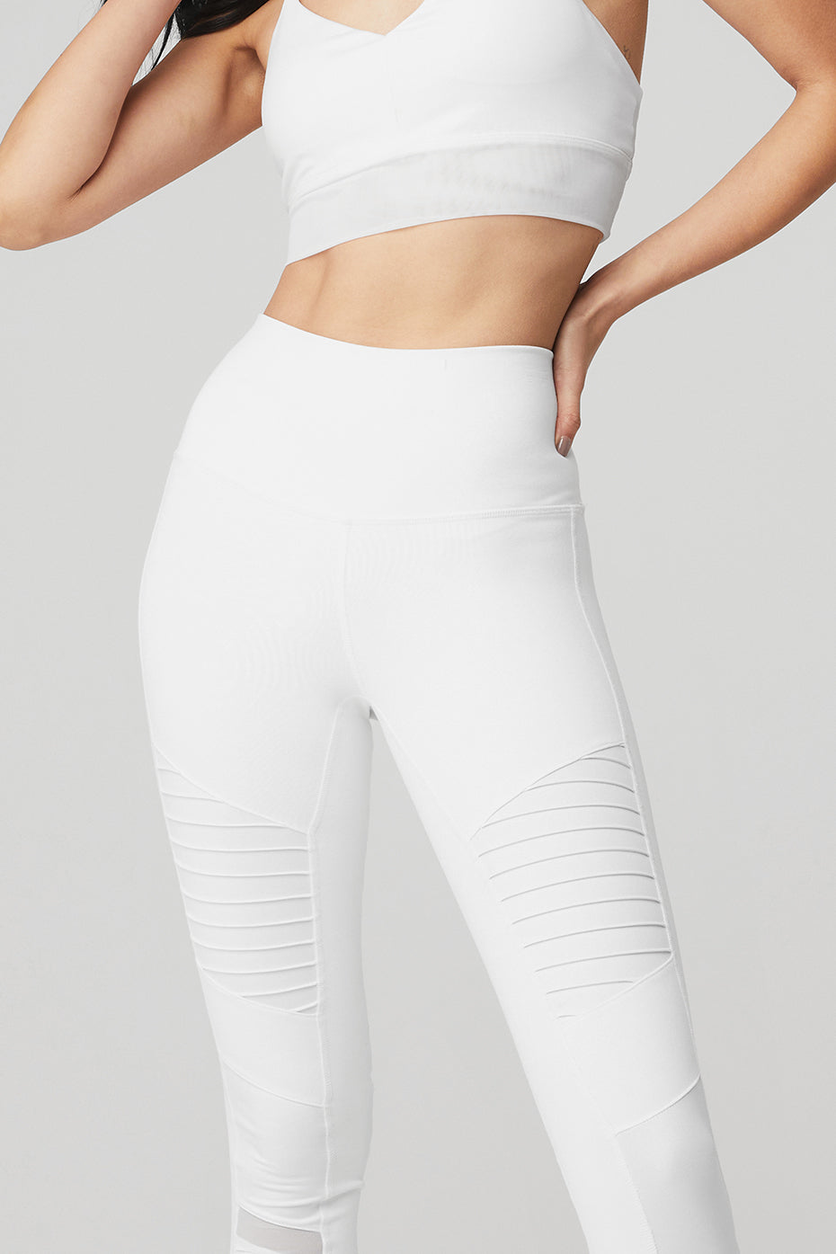 Front view of high-waisted moto leggings in glossy white for studio workouts