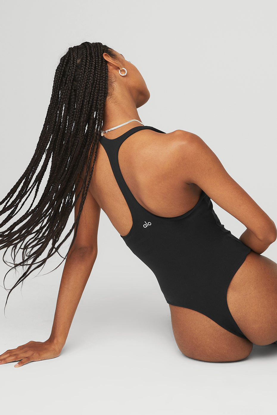 Front view of a black long sleeve bodysuit on a model, showcasing its stylish design.